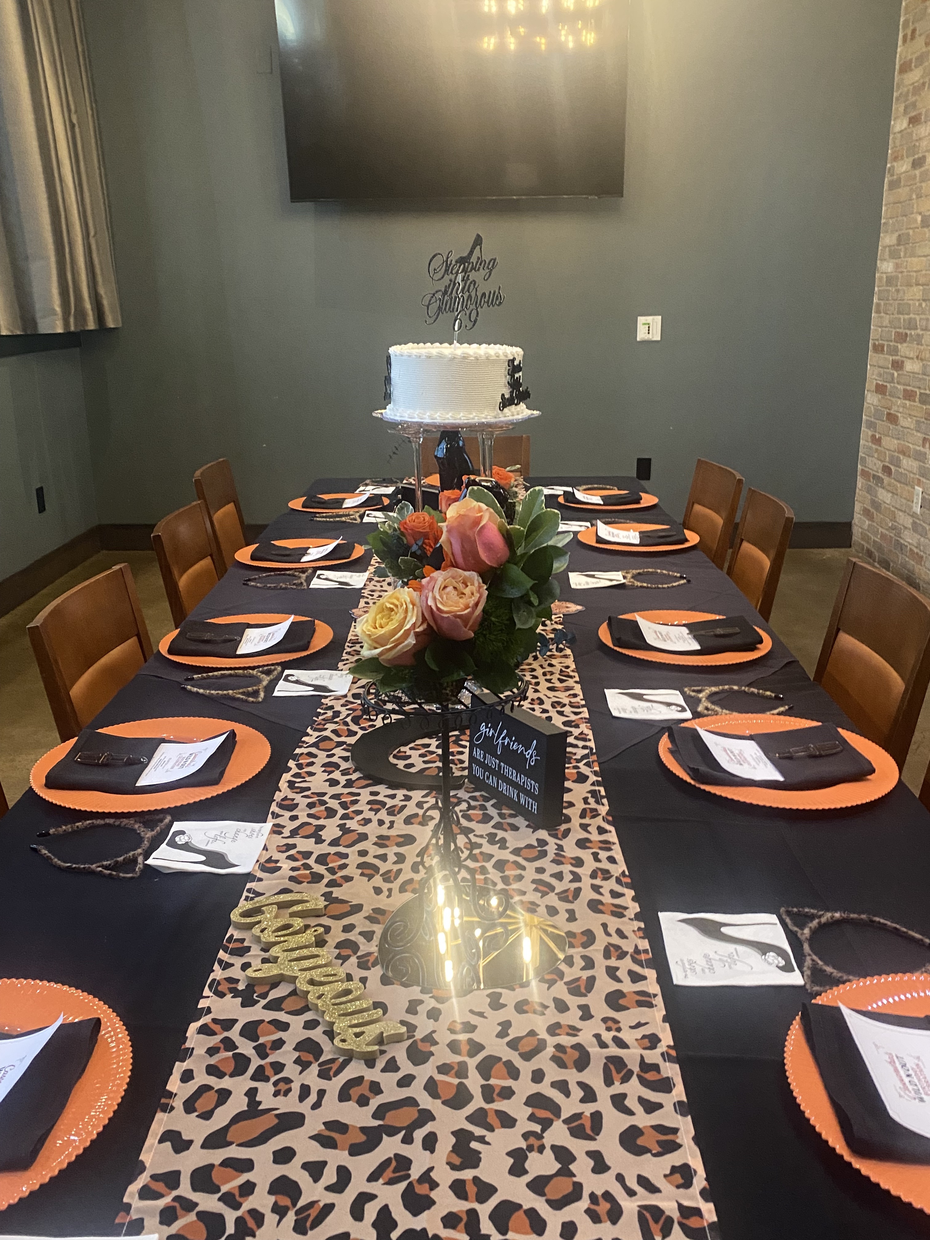 Leopard-theme dinner table with floral centerpiece and cake